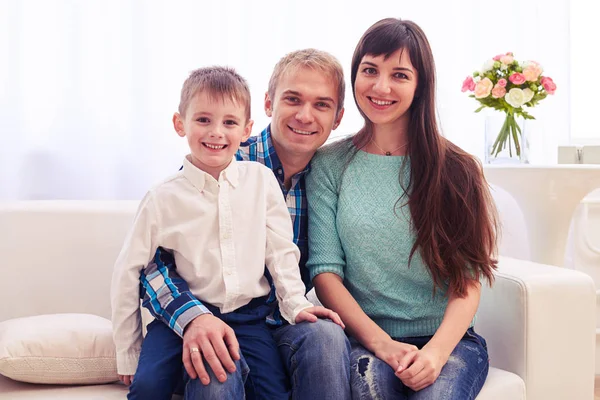 Medio tiro de alegre familia joven en casa sentado en el sofá —  Fotos de Stock