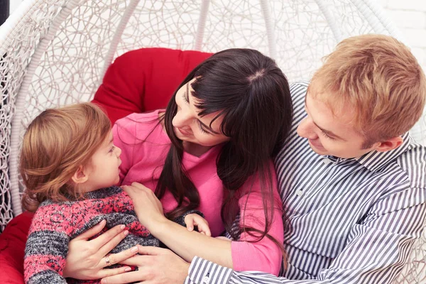 Dos padres cariñosos mirando a su bonita niña pequeña mientras posi — Foto de Stock