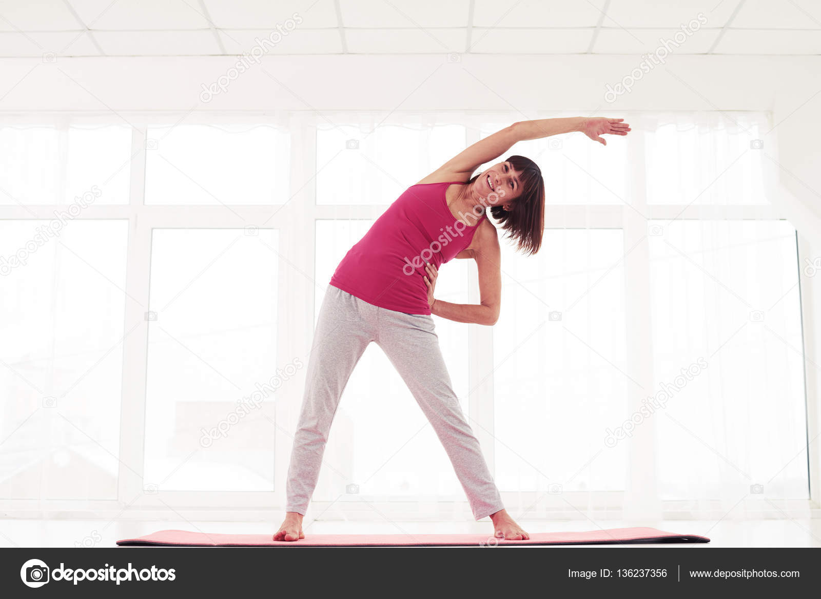 Excited model standing side stretch in the gym Stock Photo by ©konstantynov  136237356