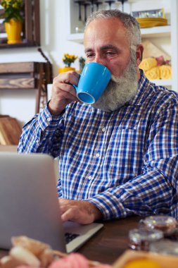 Konsantre adam bir şey bir t yaparken dizüstü bilgisayarda yazarak