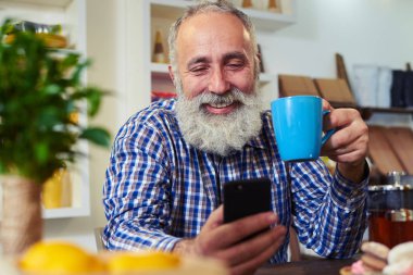 Mutfakta, oturma ve tutarak kontrol tişörtlü yakışıklı adam