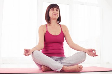 Uyumlu kadın yoga poz yaparken rahatlatıcı düşük açılı 