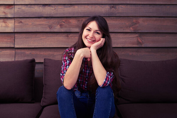 Красивая улыбающаяся девушка сидит на диване
