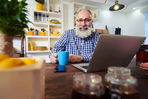 Bir fincan çay mutfak earl oturan olgun adamla sakallı