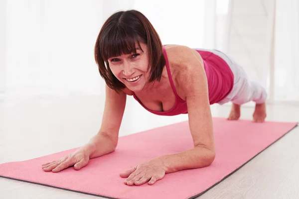 Nahaufnahme einer durchtrainierten Frau, die in Pose einer Planke steht — Stockfoto