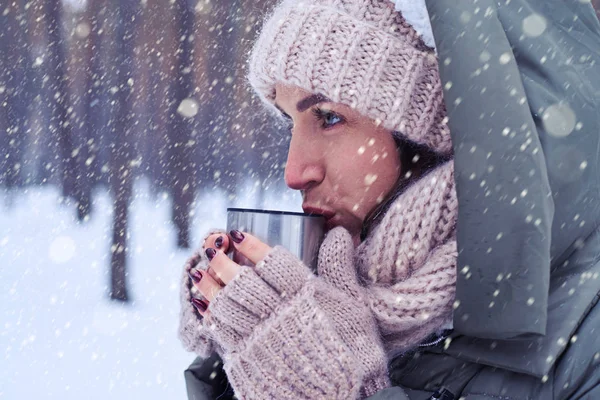 Konzentrierte Frau hält eine Tasse mit heißem Tee in der Hand — Stockfoto