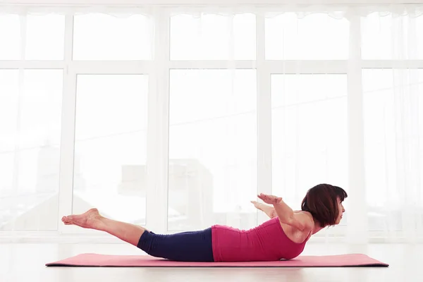 Concentrated yogini practices exercise bend yoga or cobra pose — Stock Photo, Image