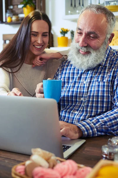 Милая молодая женщина и пожилой мужчина, смотрящий на экран сетки — стоковое фото