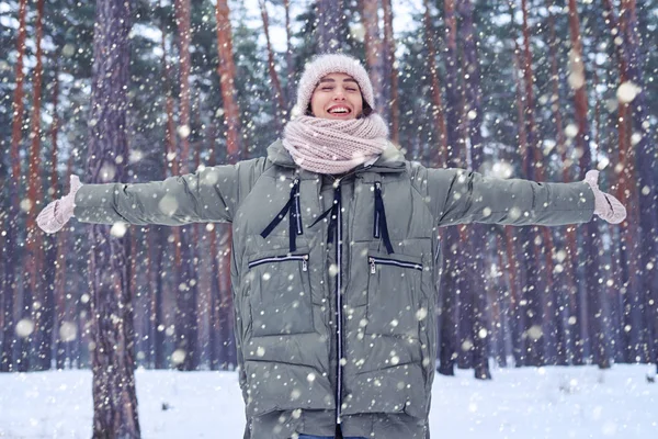 Mujer de ensueño con los ojos cerrados la captura de nieve cayendo con estiramiento — Foto de Stock