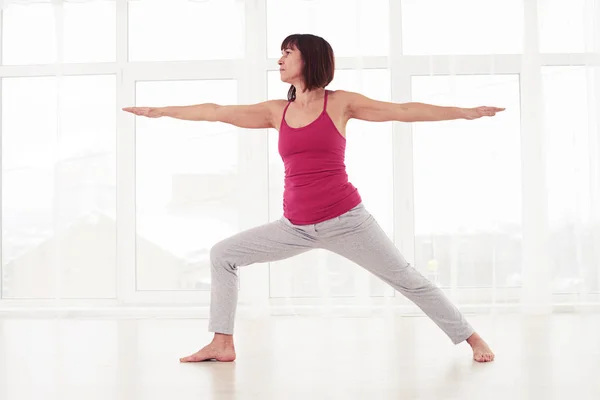 Mujer excitada de pie en pose de guerrero, practicando yoga o p —  Fotos de Stock