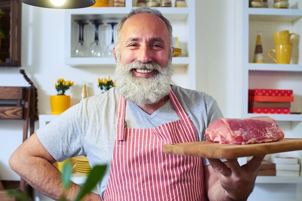 Laughing man with cutting board in hand smiling at the camera — Stock Photo, Image