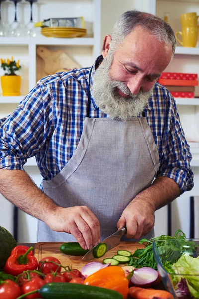 Mannen som skivning gurka isolerade i kök, närbild — Stockfoto