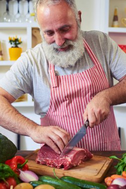 Kıdemli sakallı adam kesme kesme tahtası lezzetli çiğ biftek 