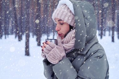 Genç kadın ormanda açık havada çay içme