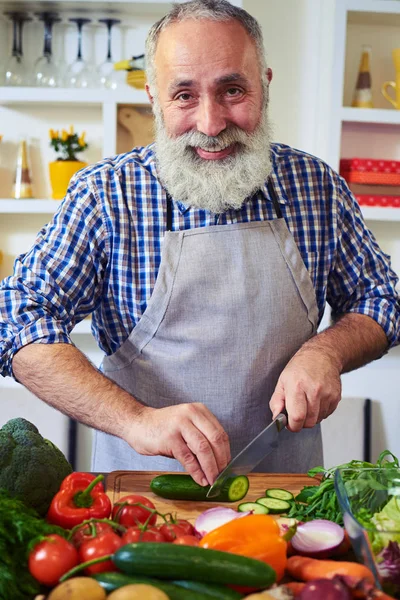 Pozitif adam kesim salatalık bir hea hazırlanırken bir bıçak ile — Stok fotoğraf
