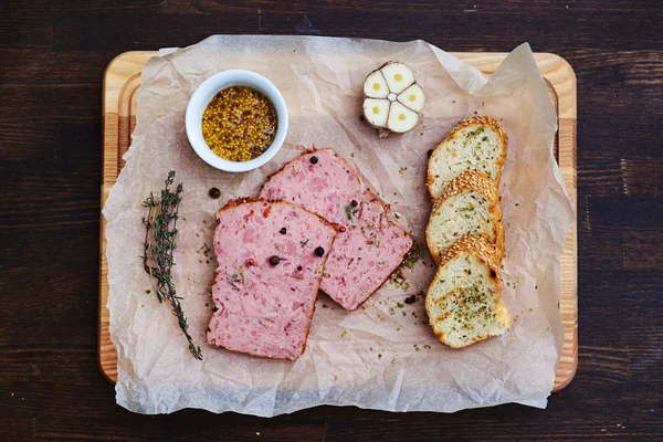 Deux morceaux de viande assaisonnée présentés avec du pain croustillant, romarin — Photo