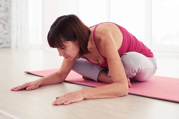 Yogini realizando pose de balasana no tapete no ginásio — Fotografia de Stock