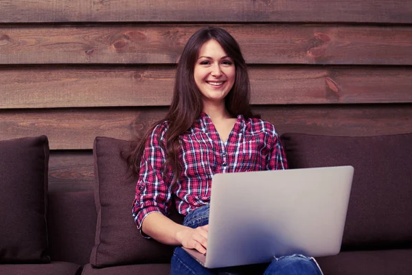 Junges hübsches Mädchen mit Laptop, das im Inneren arbeitet, während es auf th schaut — Stockfoto