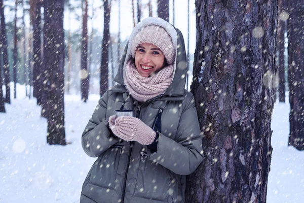 Mujer joven con abrigo caliente posando cerca de un árbol en winte frío — Foto de Stock