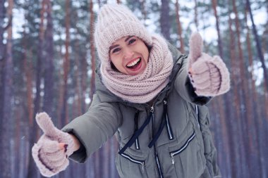 İyi görünümlü kadın iki başparmak tarafından onay gösterilmesini