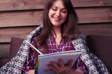 Bir jotter notlar yaparken gülümseyen yakışıklı genç kadın