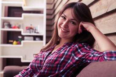 Hoş kafa üzerinde dinlenme ile kanepede oturan kız gülümseyerek