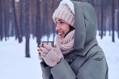 Bir fincan kahve soğuk havalarda bir kadınla gülen 