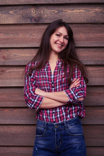 Elated model leaning on the wooden background while posing at th — Stock Photo, Image