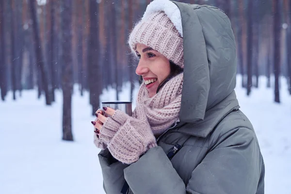 Mulher sorridente com uma xícara de café em um tempo frio — Fotografia de Stock