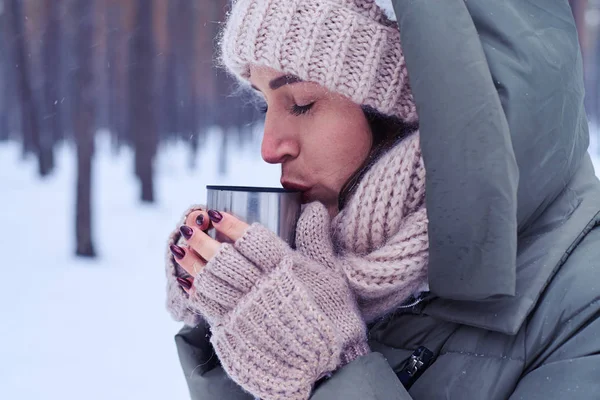 Tendre jeune femme calme dégustation de thé de tasse dans une forêt enneigée — Photo