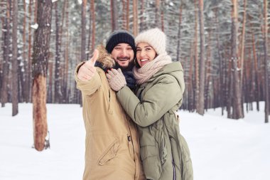 Şirin çift bir başparmak tutarak iyi bir ruh hali ifade 