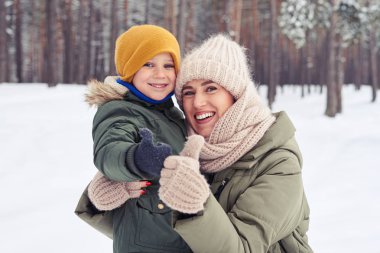 F kış yürüyüş sırasında onun güneşi kucaklayan anne gülümseyerek