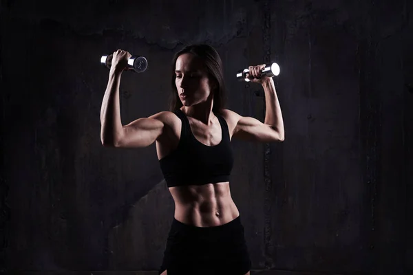Actieve sportieve sportieve vrouw kijken naar biceps tijdens het oppompen van — Stockfoto