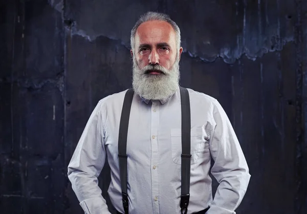 Серйозні кавказьких бородатий чоловік, що стоїть в студії ізольовані над b — стокове фото