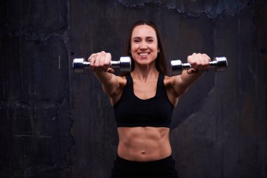 Kendine hakim kadının pazı kıvırmak dumbbells ile yapması
