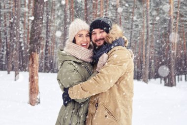 Kış yürüyüş sırasında kar yağışı altında iki sevgi dolu kişi 