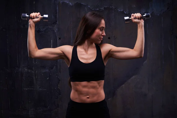 Functional training of woman performing pumping up with dumbbell — Stock Photo, Image