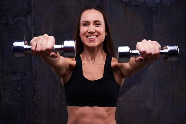 Trained sportswoman holding two dumbbells on straight hands isol — Stock Photo, Image