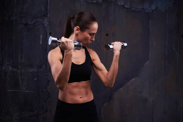 Tanned Caucasian woman in a good shape demonstrating her biceps — Stock Photo, Image