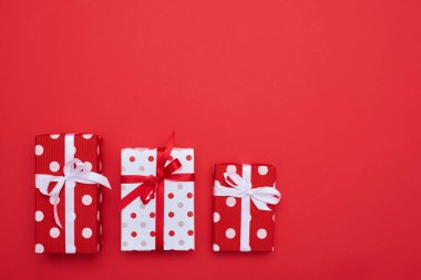 Farklı boyut hediye kutuları üzerinde kırmızı arka plan izole