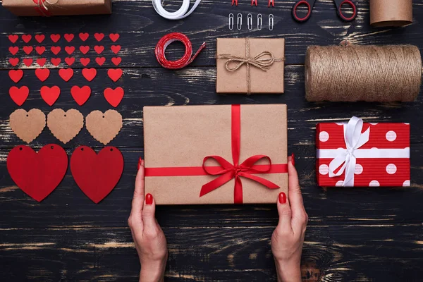 Cosas decorativas dispuestas con una caja de regalo en las manos —  Fotos de Stock