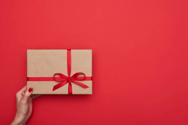 Brazo femenino sostiene caja de regalo hecha a mano en estilo vintage — Foto de Stock