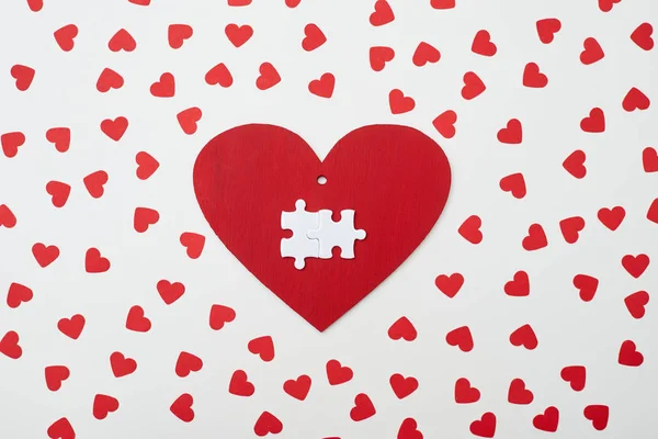 Greeting card in a form of heart with two white puzzle over it — Stock Photo, Image