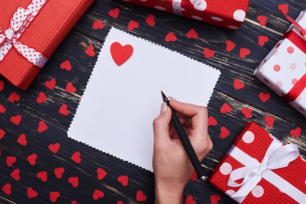 Рука, що пише вітальні листівки або любовне повідомлення ізольовано над гримом — стокове фото