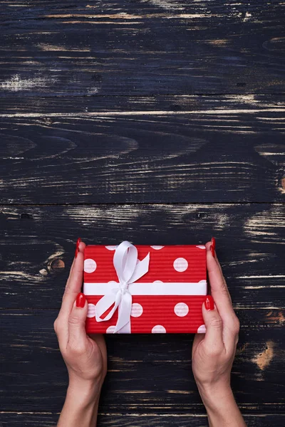 Manos sosteniendo linda caja de regalo de lunares — Foto de Stock