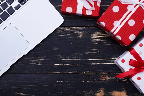 Laptop ile üç hediye kutuları grunge düz üzerinde yatıyordu arka plan 