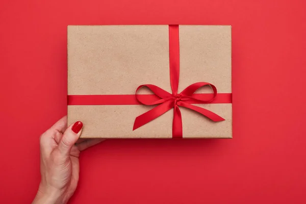 One hands holds classic gift box wrapped in a brown vintage pape — Stock Photo, Image