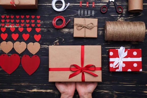 Caja de regalo no preparada en manos femeninas entre cosas decorativas —  Fotos de Stock