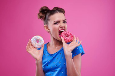 Duygusal kız pembe çörek sprinkles ile içine ısırma