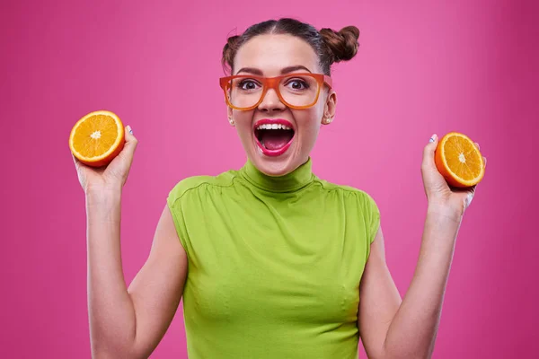 Крупный план смешной девушки с двумя кусочками апельсина — стоковое фото